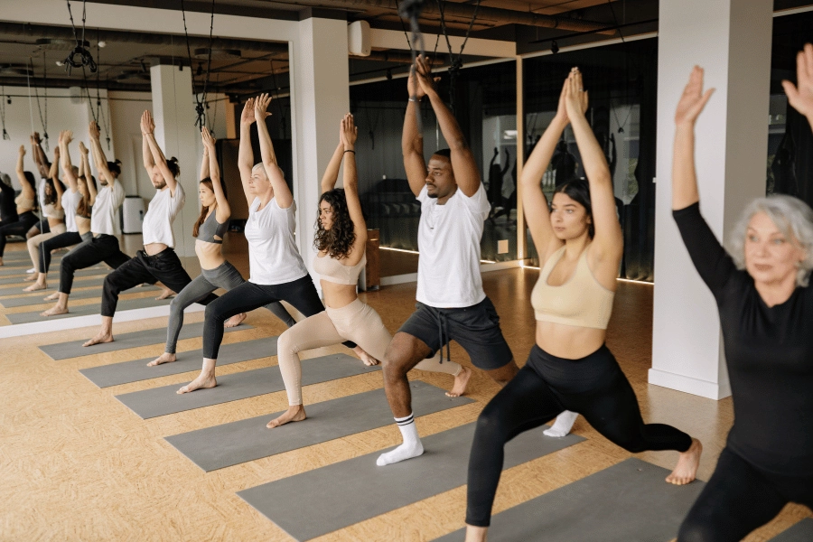 group of students in a yoga class in warrior one 